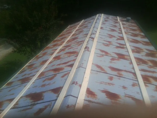 Rusted metal roof panels with new wood purlins before replacement — Storm Damage Roof Repair in Landing by Roofing Brothers