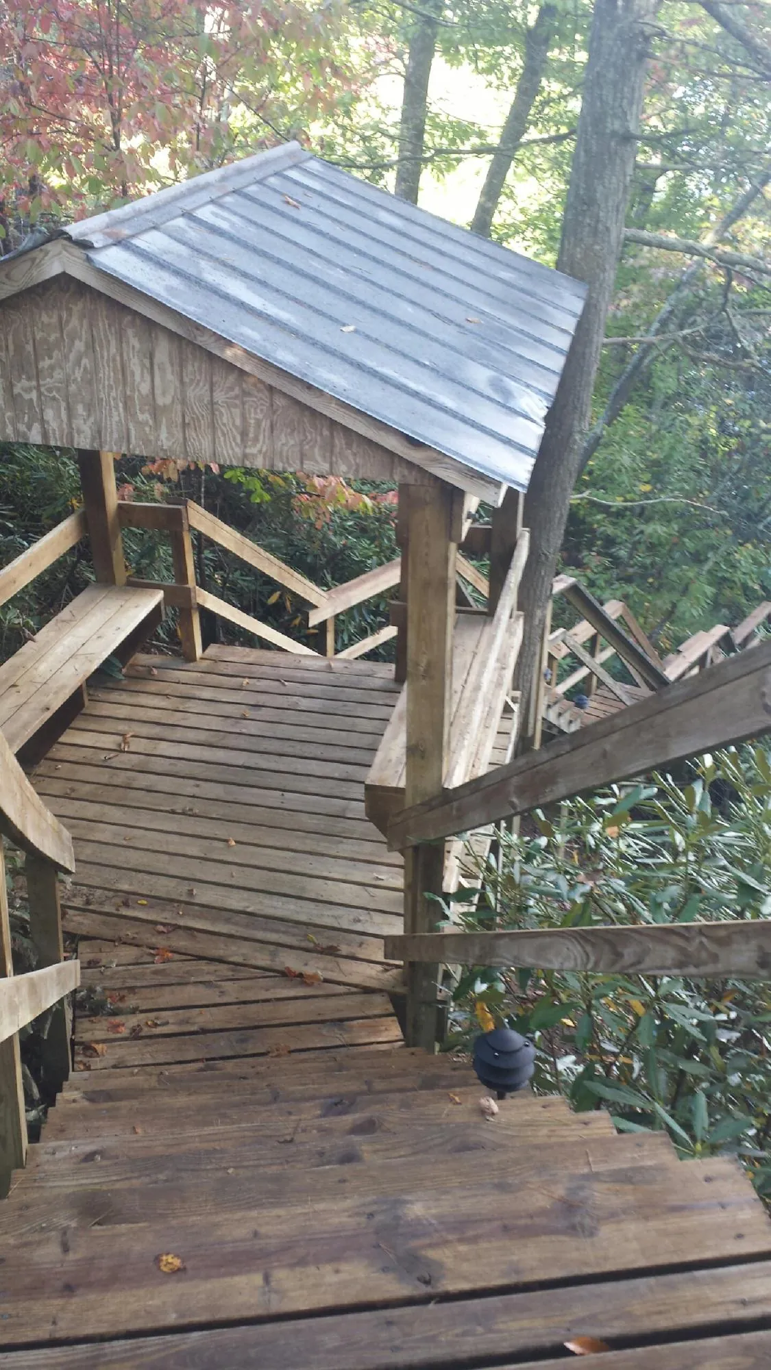 Metal roofed shelter over wooden steps on a wooded walkway — Skylight Repair & Installation work by our crew in Landing