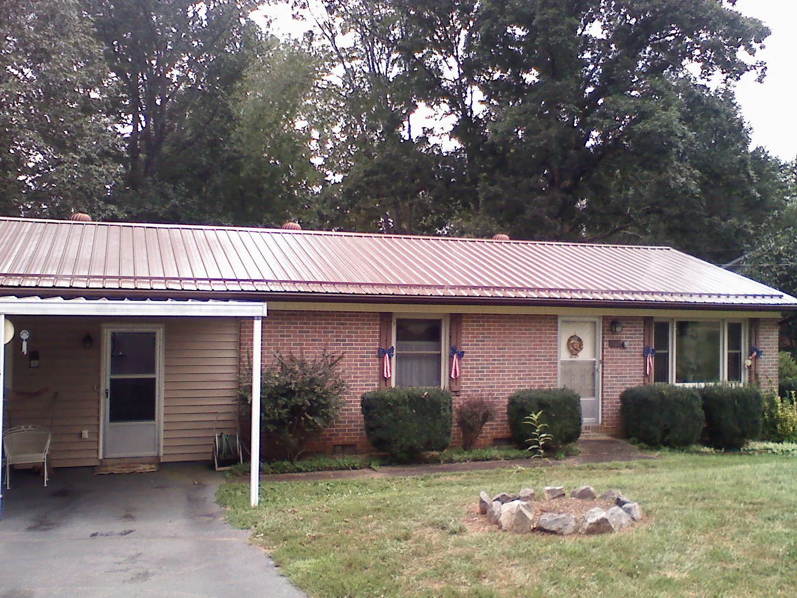 Bronze metal roof and carport on a brick ranch home — Roof Repair work by our crew in Landing