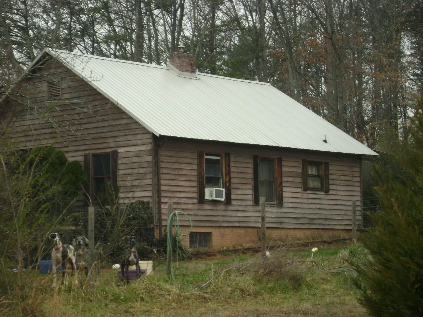 White metal roof on an old wood sided farmhouse, from a Metal Roof Installation job in Landing